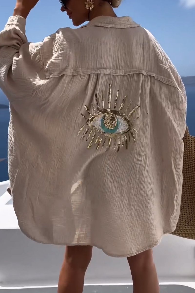 Splendida camicia oversize donna con ricamo occhio artistico e paillettes luccicanti. Perfetta per look estivi.