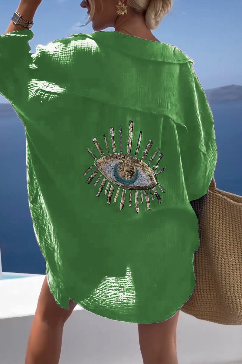 Camicia oversize donna chic, con ricamo occhio e paillettes oro. Versatile per spiaggia, casual o elegante.