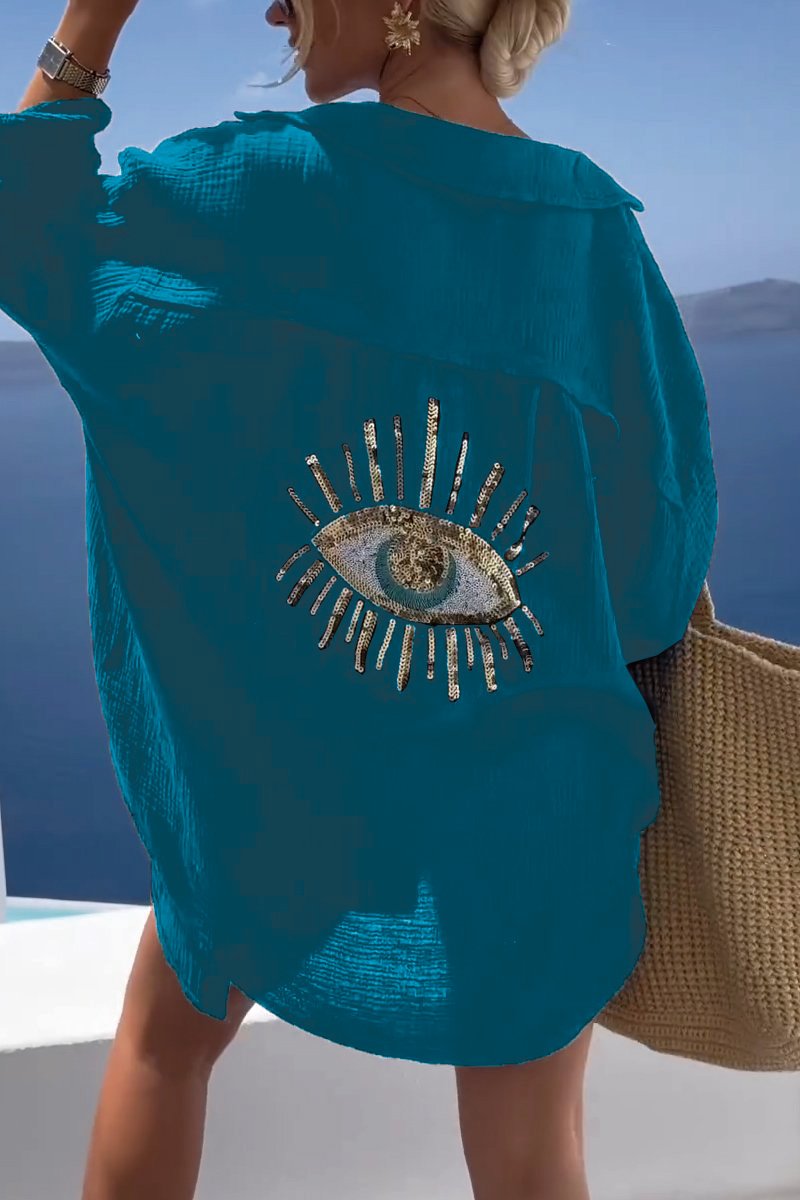 Camicia oversize donna beige con ricamo occhio e scintillanti paillettes dorate. Un tocco unico per l'estate.