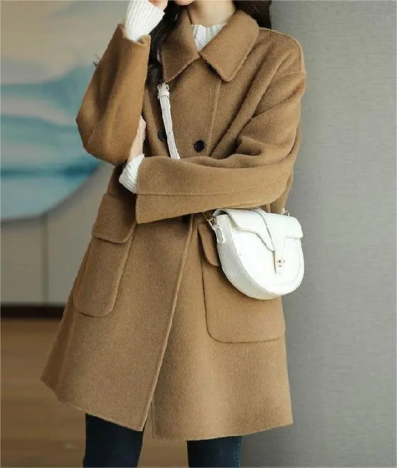 Primo piano bottoni. Cappotto donna invernale elegante con bottoni distintivi e tasche, ideale per un look versatile.