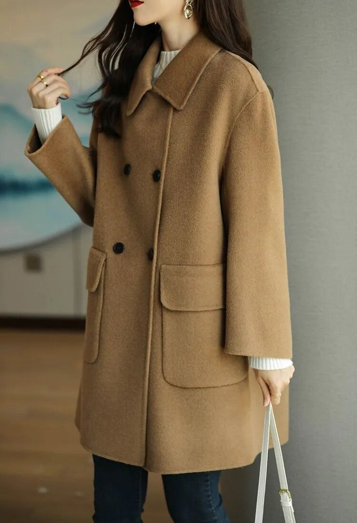 Vista frontale. Cappotto donna invernale lungo, elegante, con bottoni e tasche, ideale come capospalla caldo e versatile.