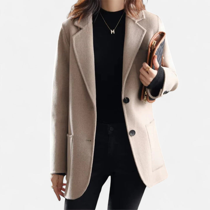 Elegante cappotto donna con design a revers a punta e bottoni scuri a contrasto. Perfetto capospalla.