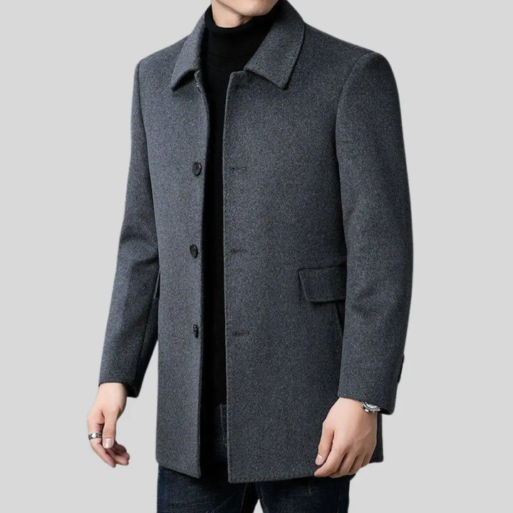 Uomo indossa cappotto classico sartoriale grigio, per un look elegante. Abbigliamento maschile autunno/inverno.