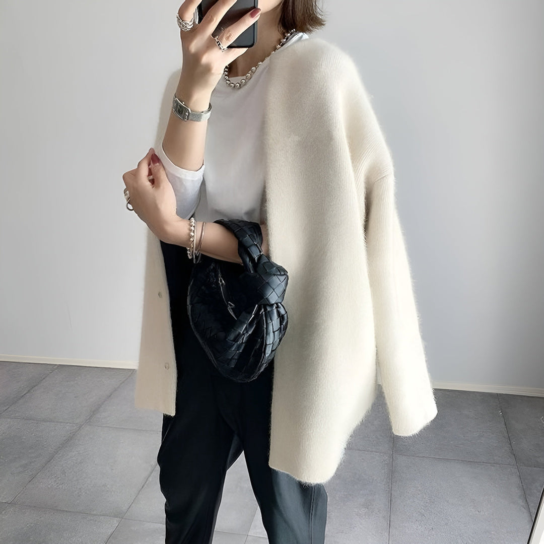 Cardigan oversize da donna bianco in maglieria, aperto e comodo, ideale per look casual e di tendenza autunno/inverno.
