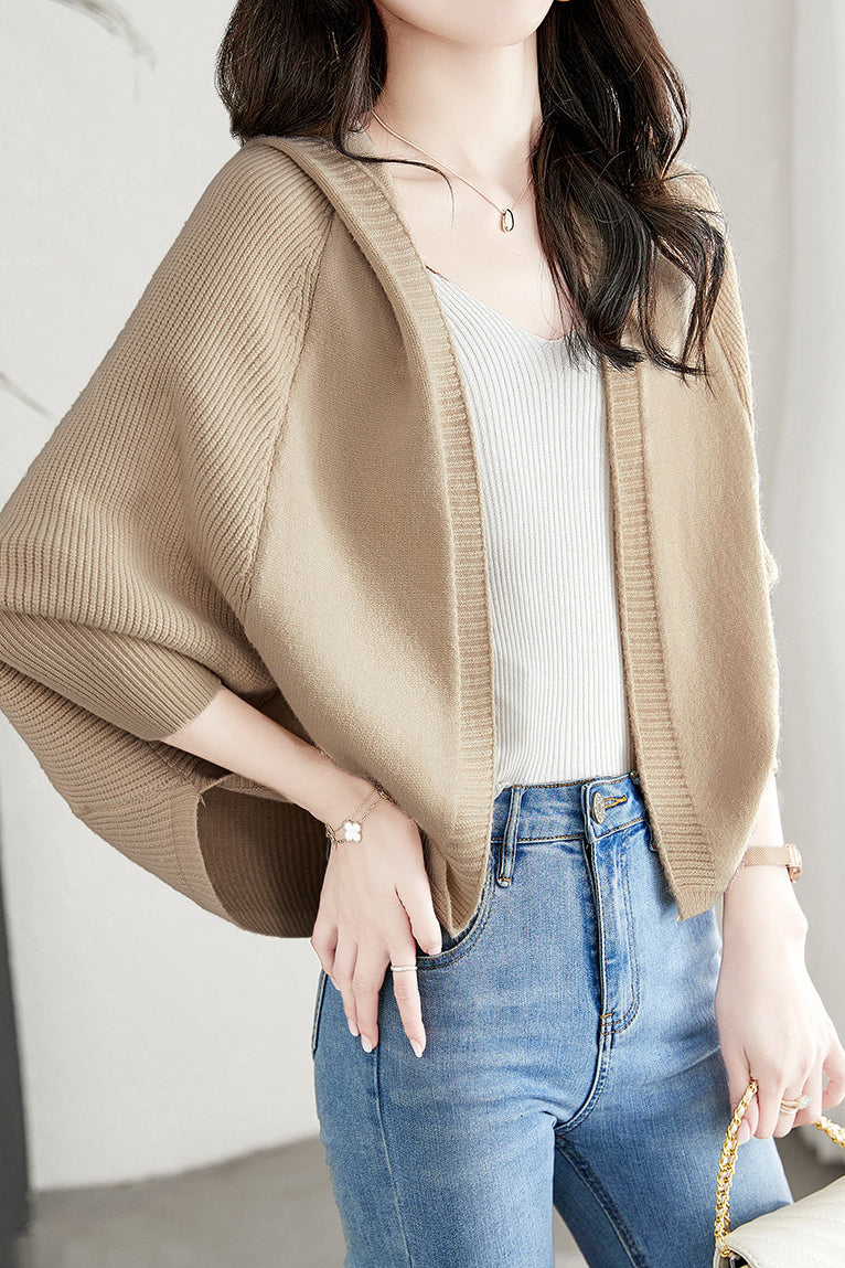 Comodo cardigan autunnale da donna con cappuccio e ampie maniche a pipistrello. Ideale per il casual chic.