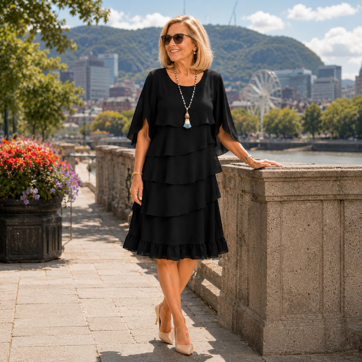 Elegante abito cerimonia donna nero con volant a strati e maniche fluide. Perfetto per eventi speciali e feste.