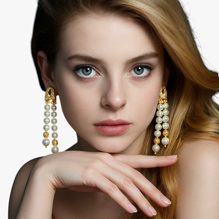 Orecchini pendenti in oro da donna con un distintivo elemento sferico, gioielli raffinati e di tendenza.