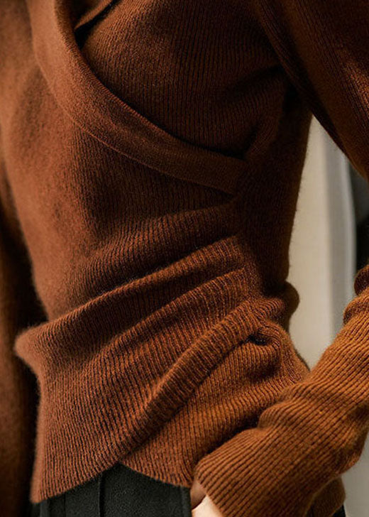 Maglione nero da donna, maniche lunghe, collo Peter Pan, taglio aderente e orlo asimmetrico.