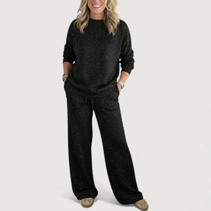 Outfit coordinato donna completo due pezzi per il relax, con top girocollo e pantaloni ampi. Effetto brillante casual.
