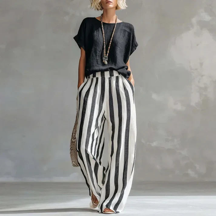 Completo donna casual chic: top ampio e pantalone vita alta a righe verticali. Outfit coordinato primavera estate.