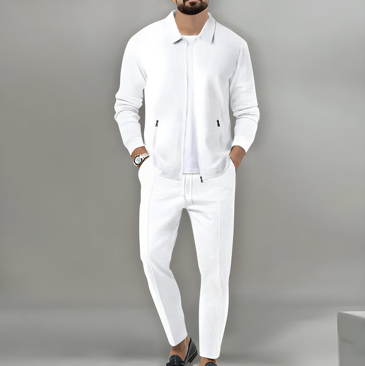 Giacca uomo con zip e collo alto in tessuto a rilievo, parte del completo due pezzi. Stile elegante e confortevole maschile.