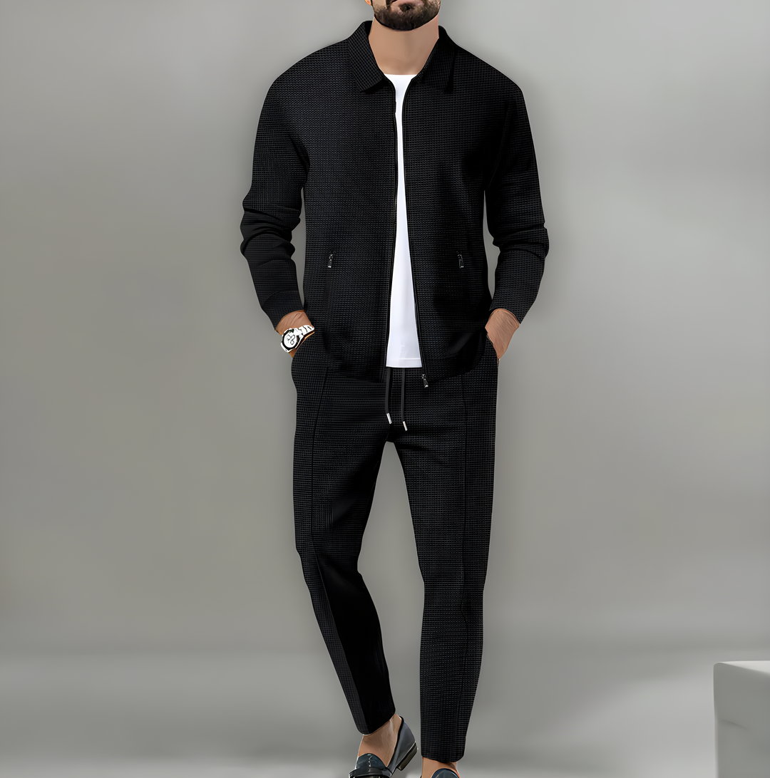 Completo due pezzi uomo casual, giacca con zip e pantaloni coordinati in tessuto a rilievo. Look confortevole primavera/autunno.