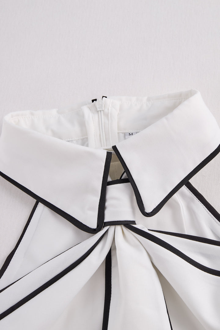 Moderna blusa donna estiva senza maniche, scollo all'americana. Finiture contrastanti per un look chic.