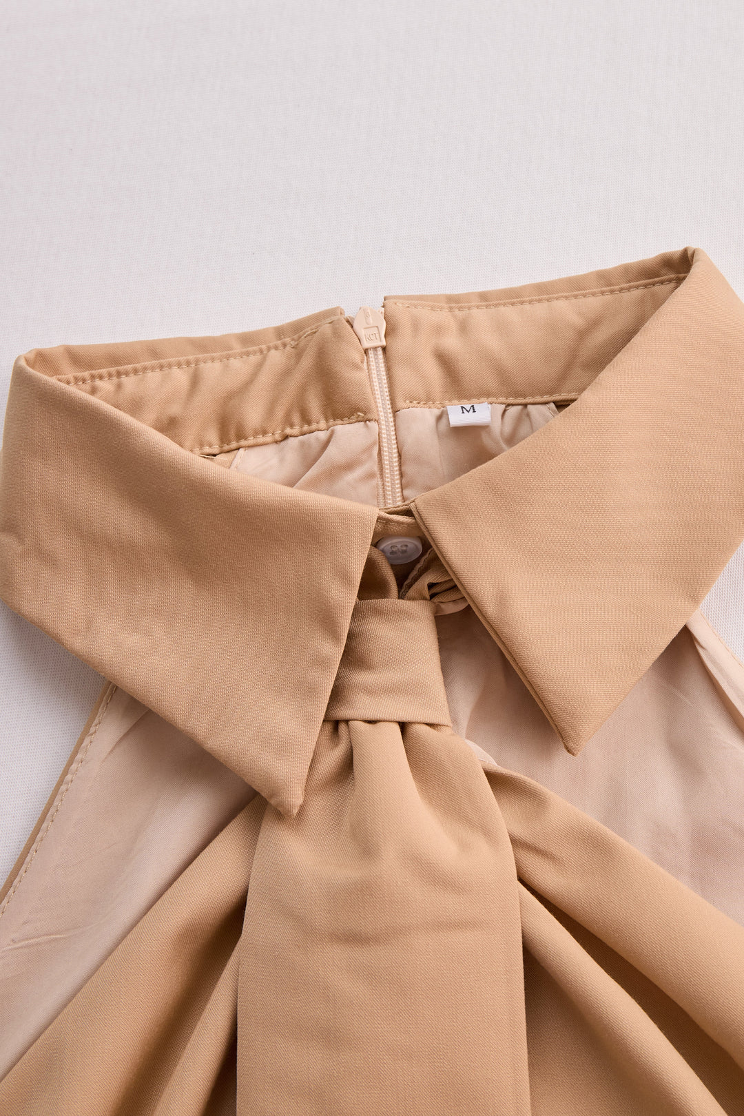 Elegante blusa bianca senza maniche con nodo, capo must-have per la moda femminile primavera estate.