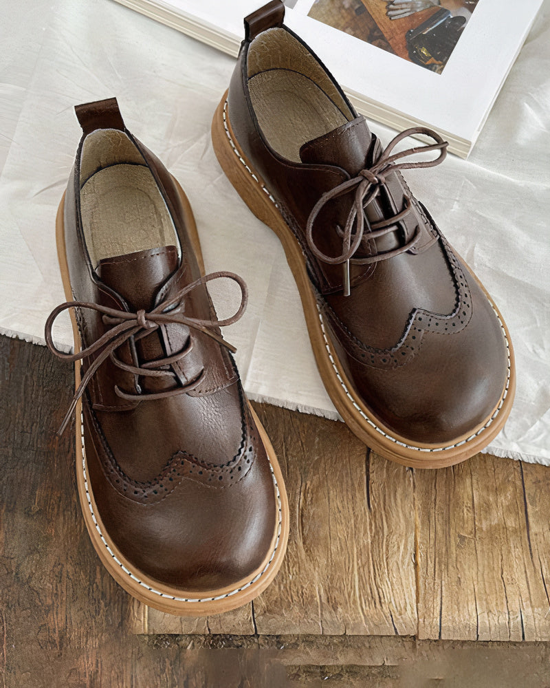 Dettaglio scarpa Oxford donna in pelle nera lucida, con lacci e cuciture di qualità, per un'eleganza senza tempo.