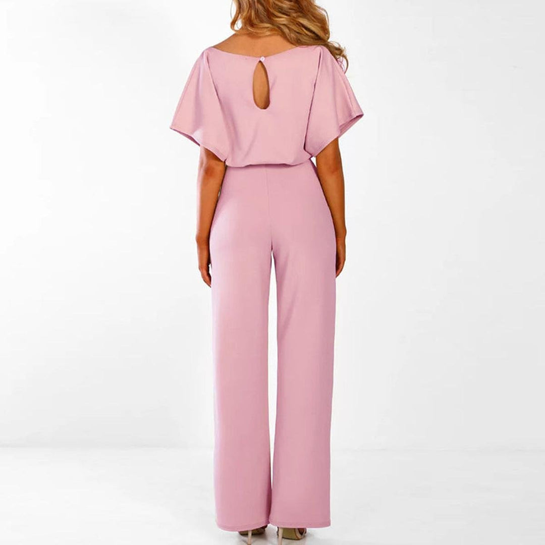 Modella indossa tuta intera donna con pantaloni a gamba larga e cintura. Abbigliamento femminile alla moda.
