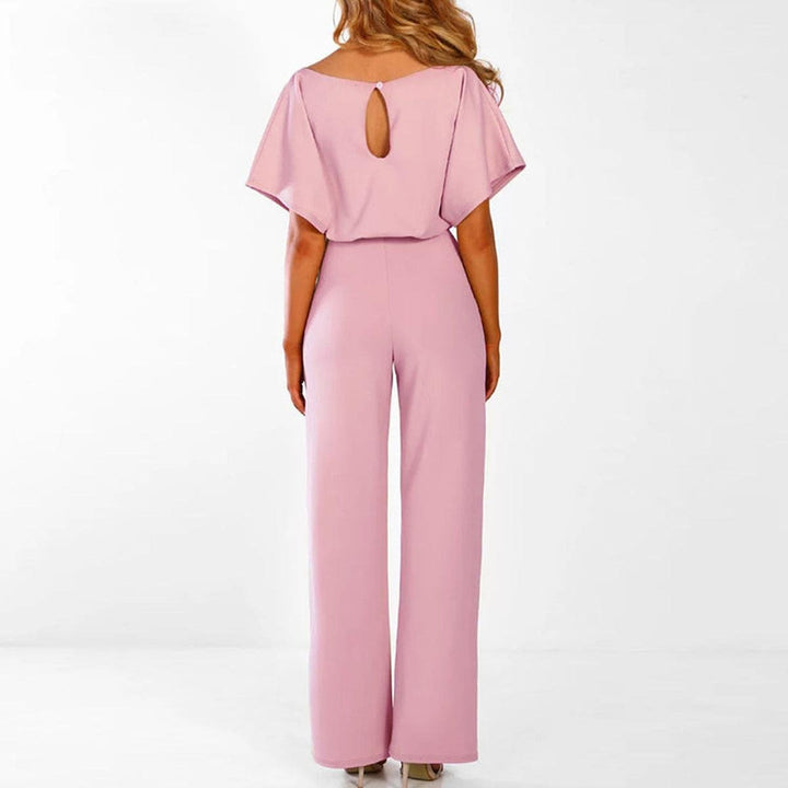 Modella indossa tuta intera donna con pantaloni a gamba larga e cintura. Abbigliamento femminile alla moda.