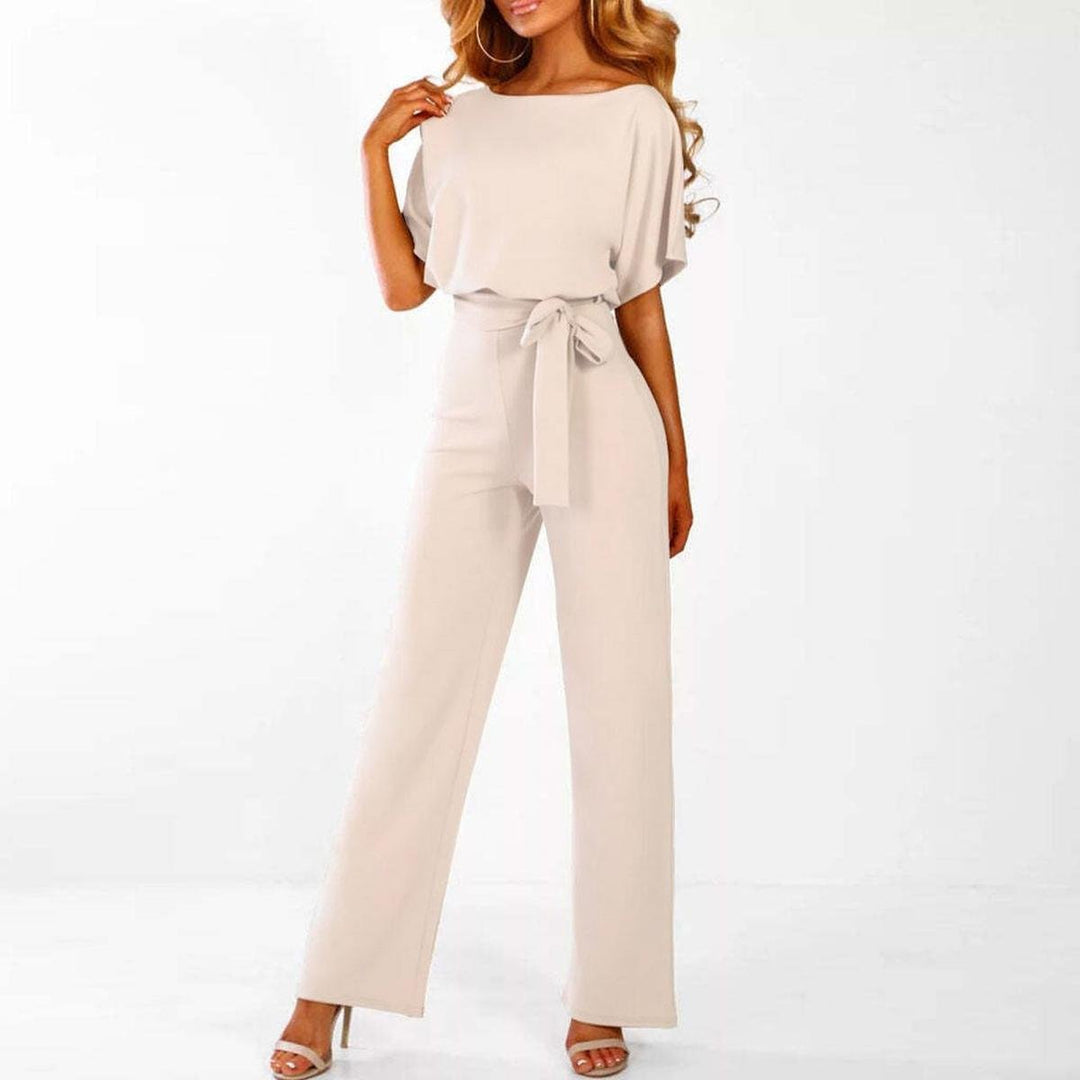 Tuta intera donna con cintura, visibile frontalmente. Pantaloni larghi. Elegante abbigliamento femminile di moda.