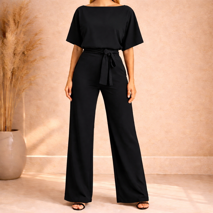 Dettaglio fiocco in vita su tuta donna elegante nera, ideale per un look da cerimonia o sera chic.