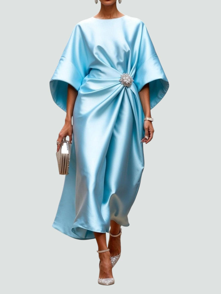 Abito da sera donna beige, drappeggiato, con raffinato dettaglio gioiello in vita. Perfetto per occasioni formali.