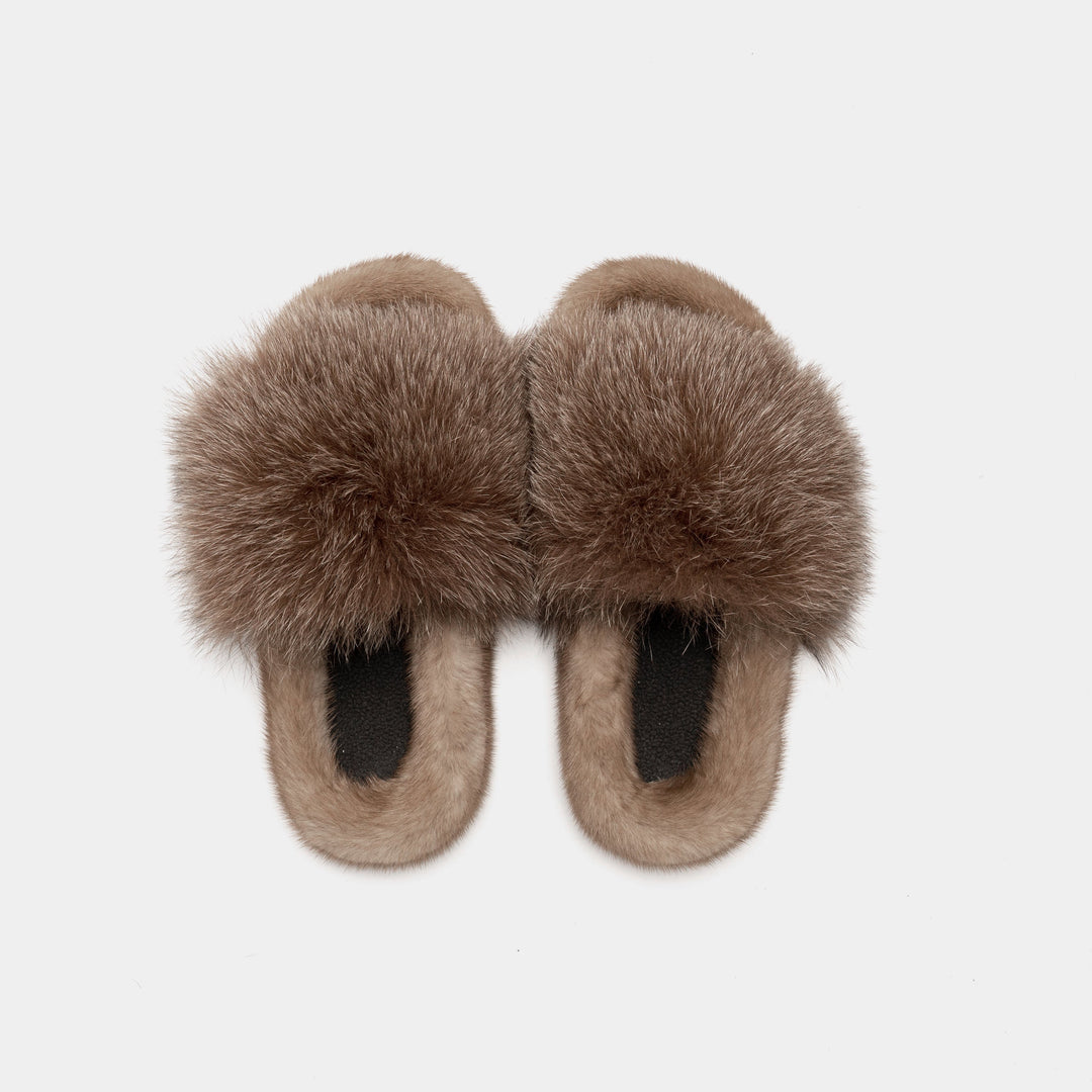 Donna che indossa pantofole calde e morbide con fascia in pelliccia, perfette per relax in casa. Antiscivolo.