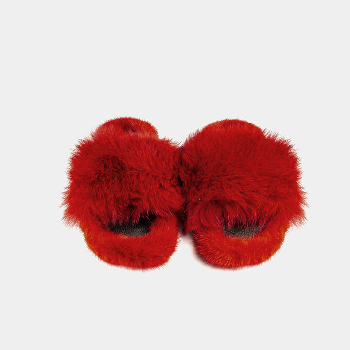Primo piano di pantofole rosse donna in pelliccia di volpe e visone, simbolo di comfort e lusso.