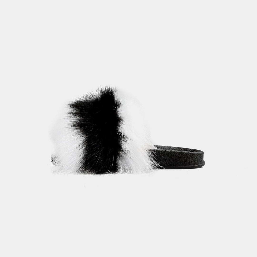 Pantofole da donna eleganti con pelliccia di volpe bicolore (nero/bianco) indossate, perfette per il relax a casa.