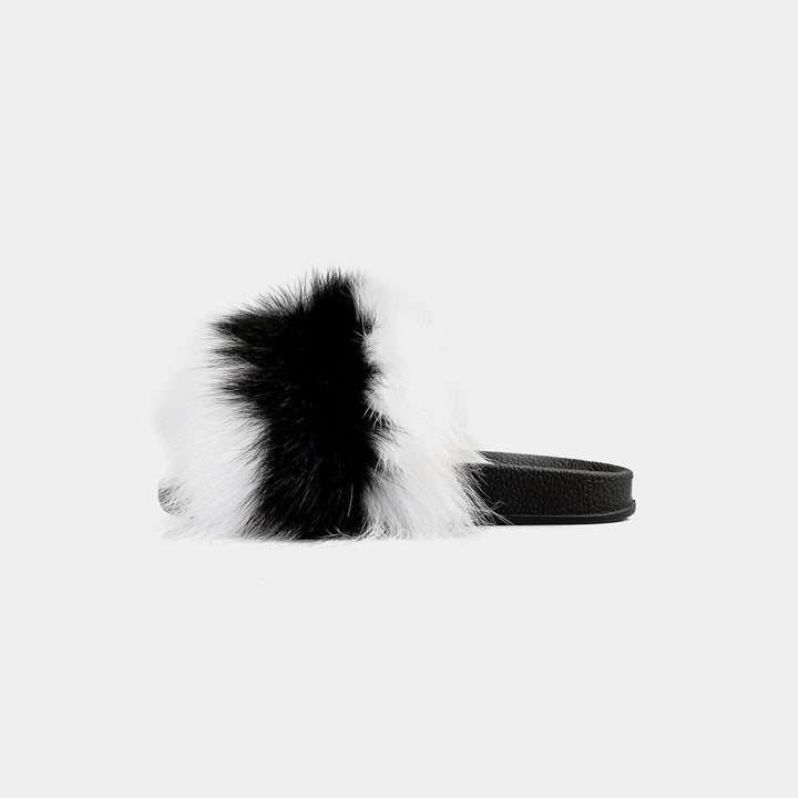Pantofole da donna eleganti con pelliccia di volpe bicolore (nero/bianco) indossate, perfette per il relax a casa.
