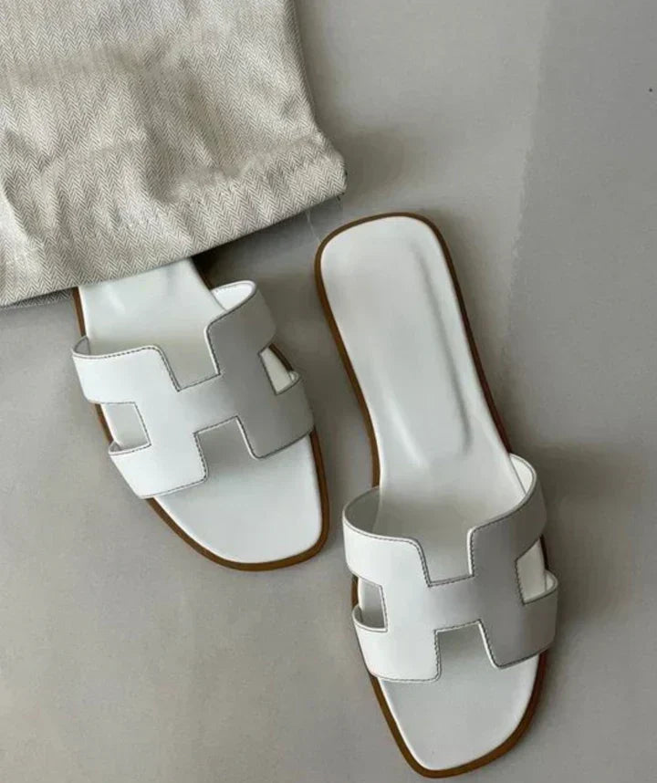 Sandali donna eleganti con fasce ad H in pelle bianca e tacco basso. Perfetti per l'estate.