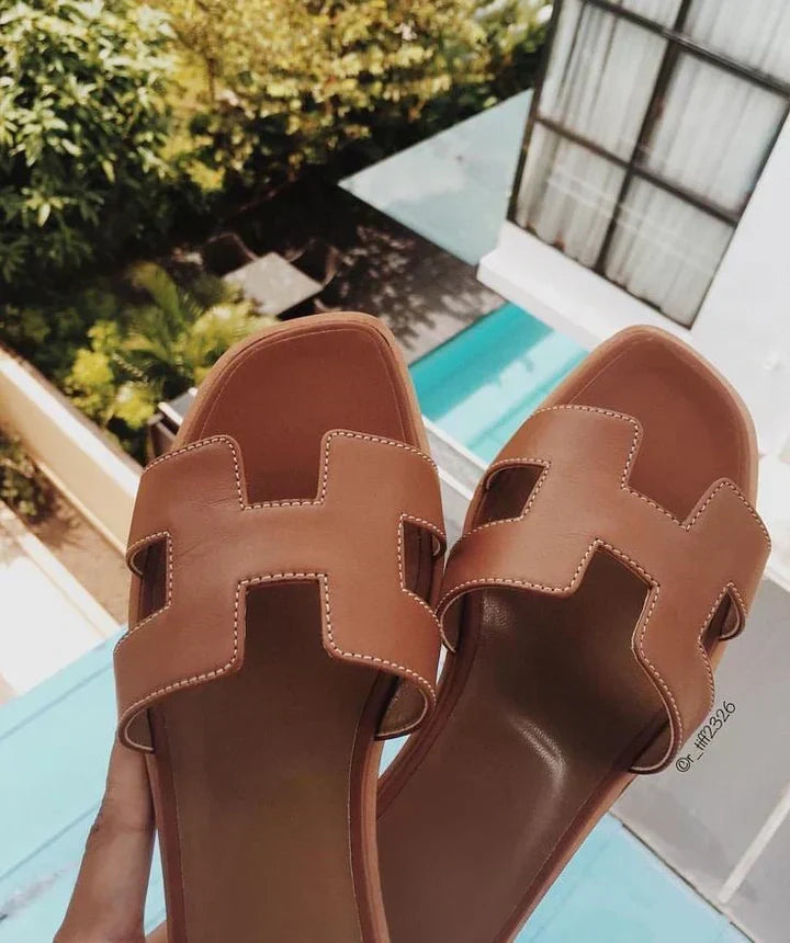 Sandali donna con fasce ad H nere, tacco basso, perfetti per look eleganti o casual estivi.