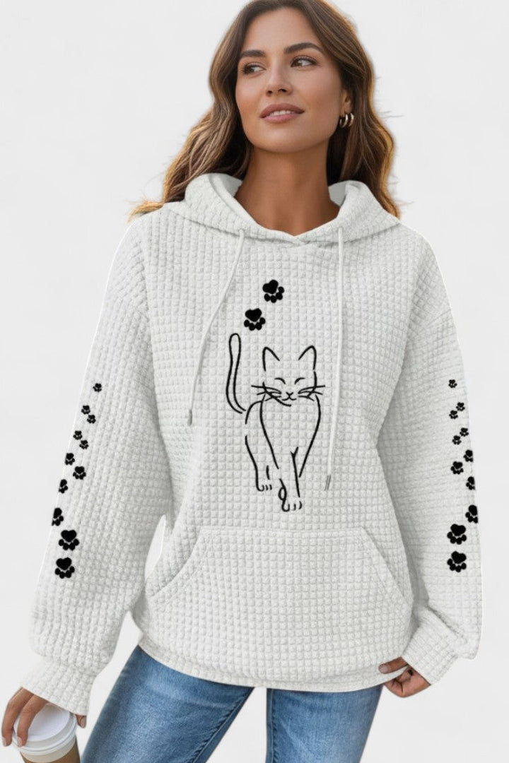 Donna indossa felpa con cappuccio e tasca a marsupio. Stile casual e comfort in un unico capo.