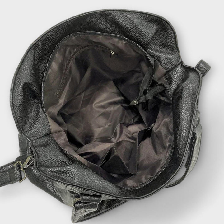 Donna indossa borsa hobo morbida a spalla. Accessorio moda quotidiano che aggiunge eleganza ad ogni look.