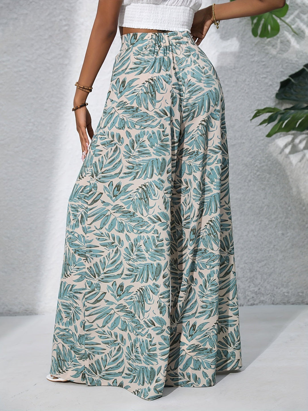 Dettaglio stampa floreale su pantaloni palazzo da donna fluidi, ideali per un look estivo elegante.