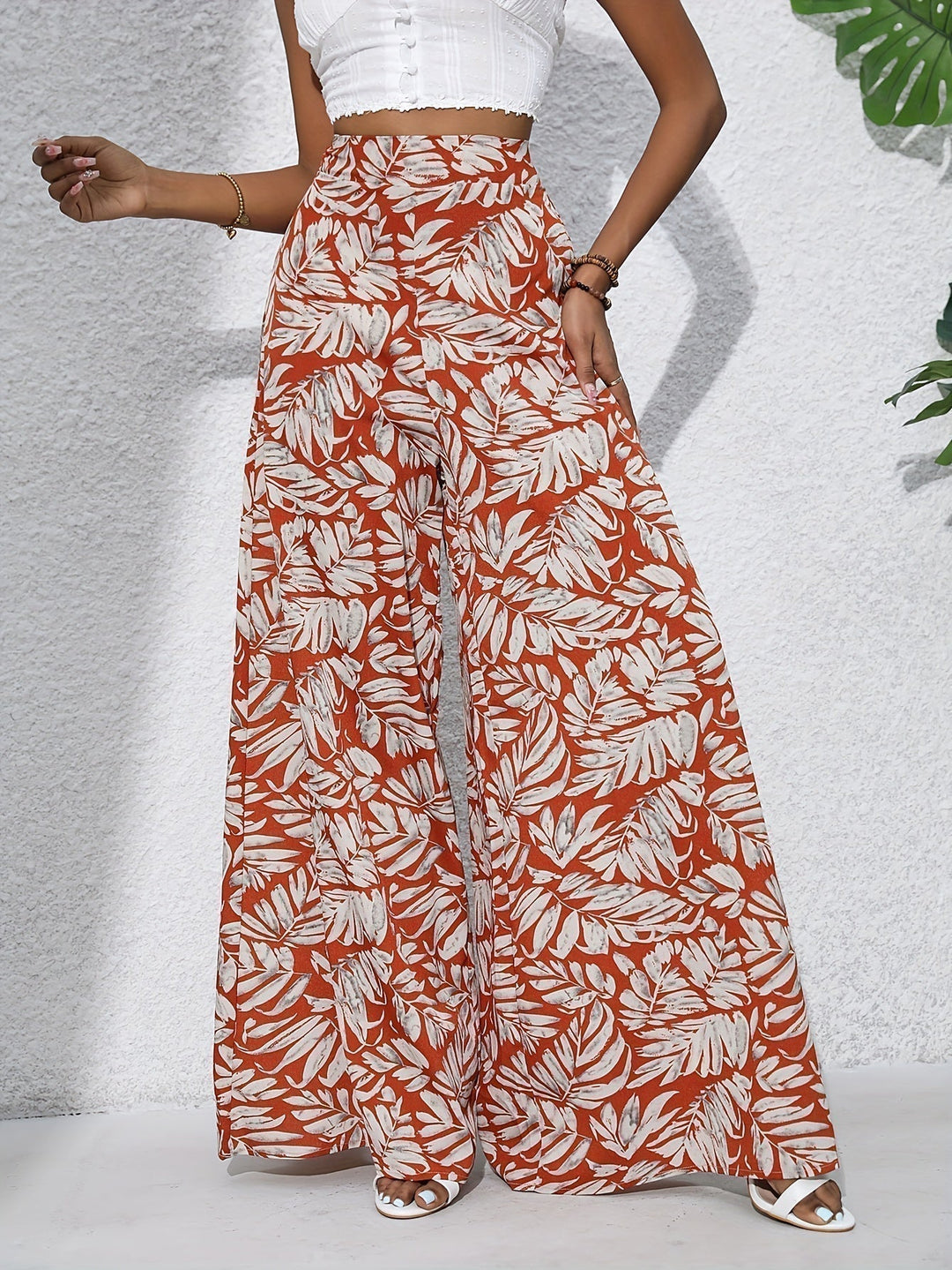 Pantaloni palazzo floreali donna, vestibilità ampia e vita alta, ideali per un look estivo elegante e fluido.