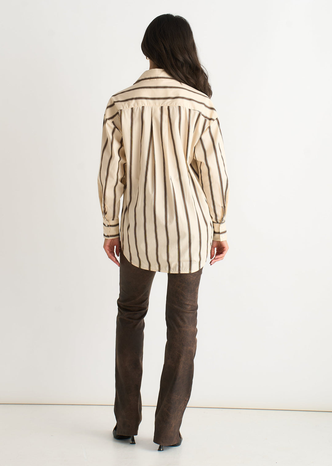 Moderna camicia donna a righe crema. Blusa versatile a maniche lunghe con bottoni, abbigliamento femminile chic.