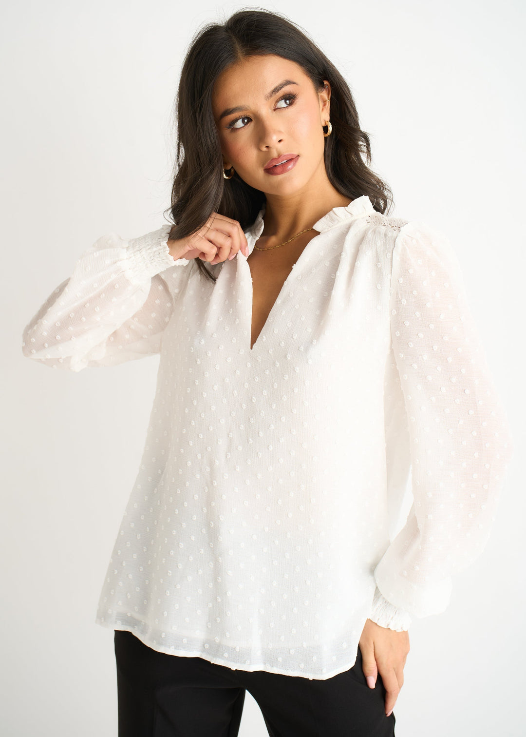 Top donna bianco con maniche lunghe e collo a volant, ideale per abbigliamento ufficio o outfit casual chic.