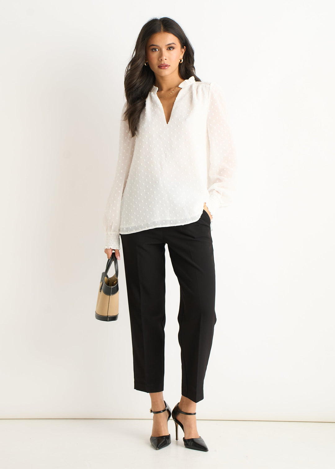 Blusa bianca femminile con dettagli in volant sul collo e maniche lunghe, un capo di moda versatile per ogni donna.