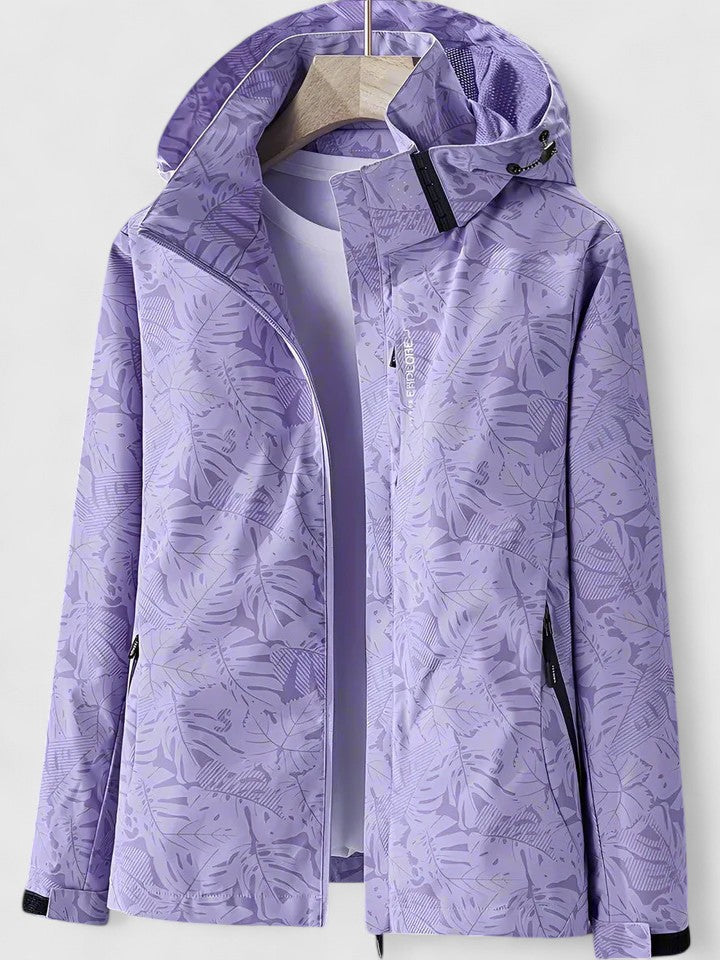 Giacca casual da donna con cappuccio e fantasia tropicale, ideale per un look primaverile o autunnale.