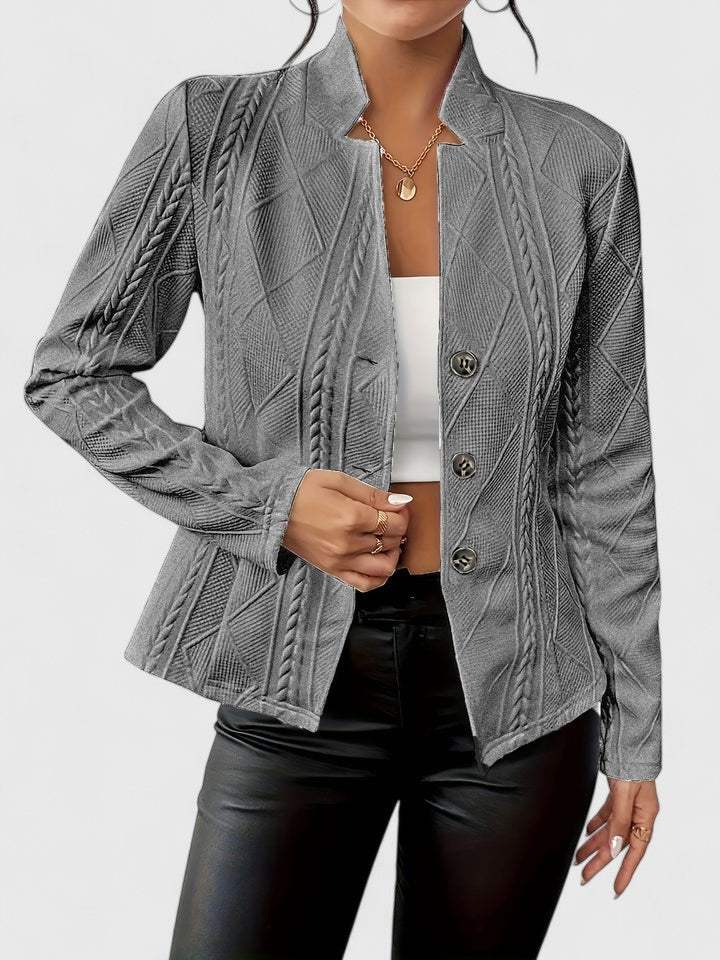 Giacca da donna sagomata con distintiva texture a rilievo, bottoni decorativi. Ideale per moda autunno/inverno.
