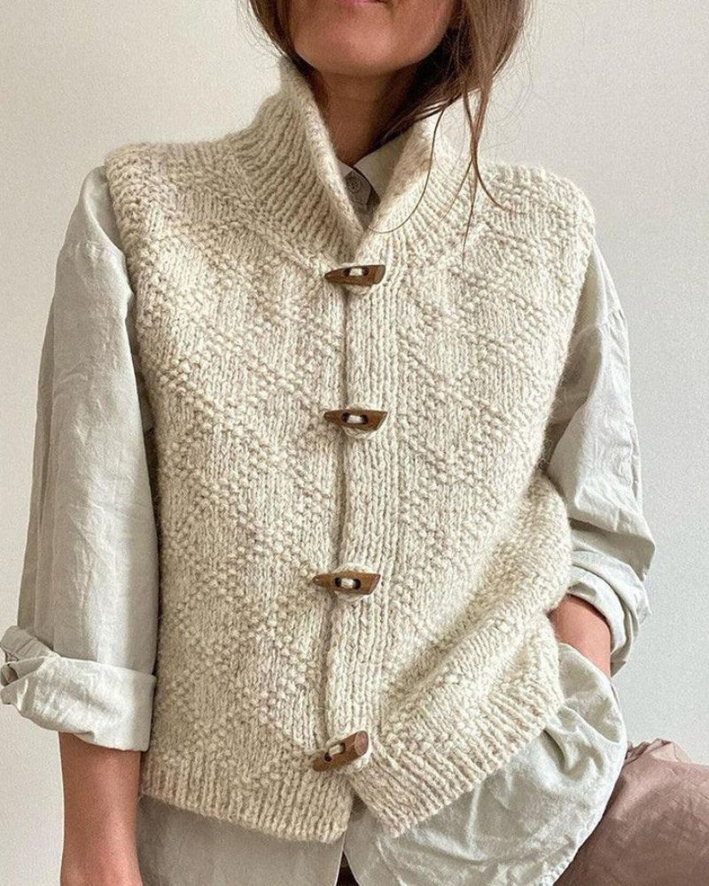 Gilet donna senza maniche in maglia, collo alto e bottoni artigianali. Abbigliamento versatile per autunno.