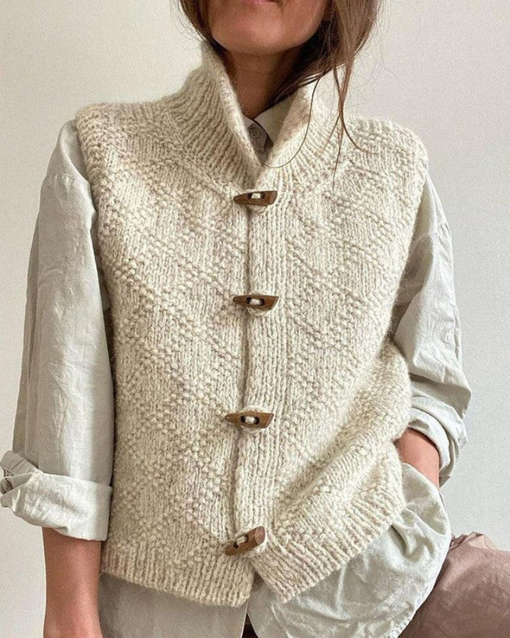 Gilet donna senza maniche in maglia, collo alto e bottoni artigianali. Abbigliamento versatile per autunno.