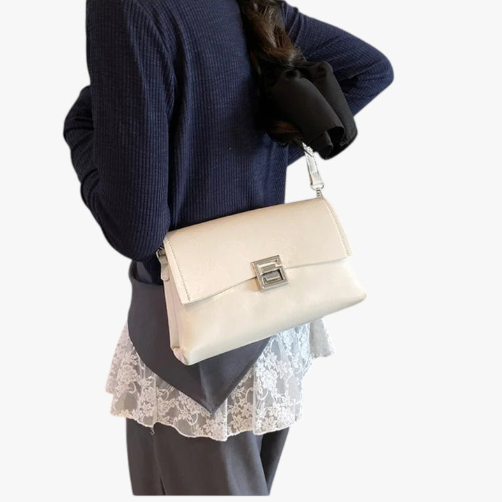 Borsa donna bianca in materiale sintetico, elegante con chiusura frontale e tracolla versatile per look sofisticati.