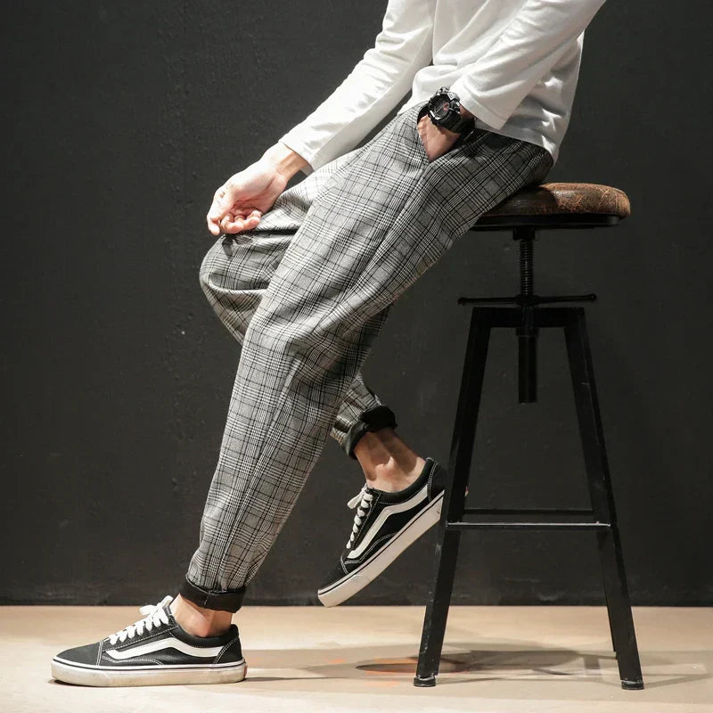 Pantaloni uomo eleganti a quadri, vita elasticizzata. Tessuto morbido e comodo, ideali per la moda maschile casual chic.