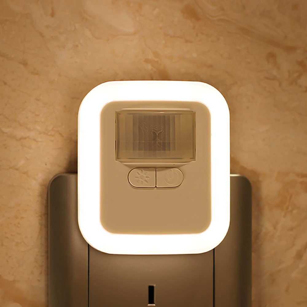 Elegante luce notturna LED bianca, con sensore di movimento integrato, per illuminazione smart e sicura.