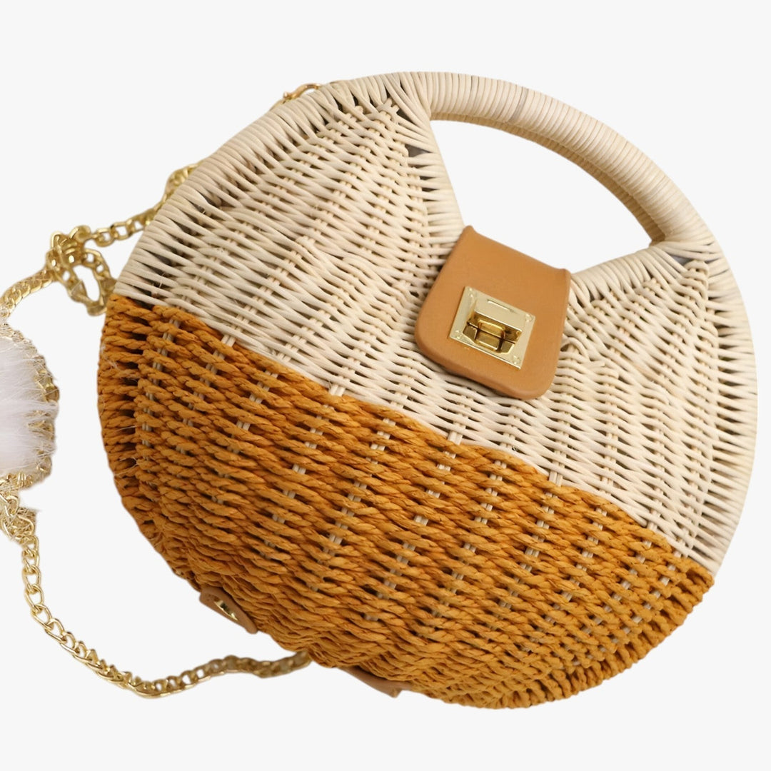 Elegante borsa da donna rotonda in paglia intrecciata, ideale per un look estivo e chic.