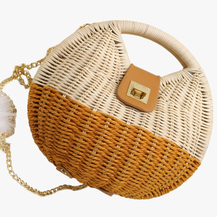 Elegante borsa da donna rotonda in paglia intrecciata, ideale per un look estivo e chic.