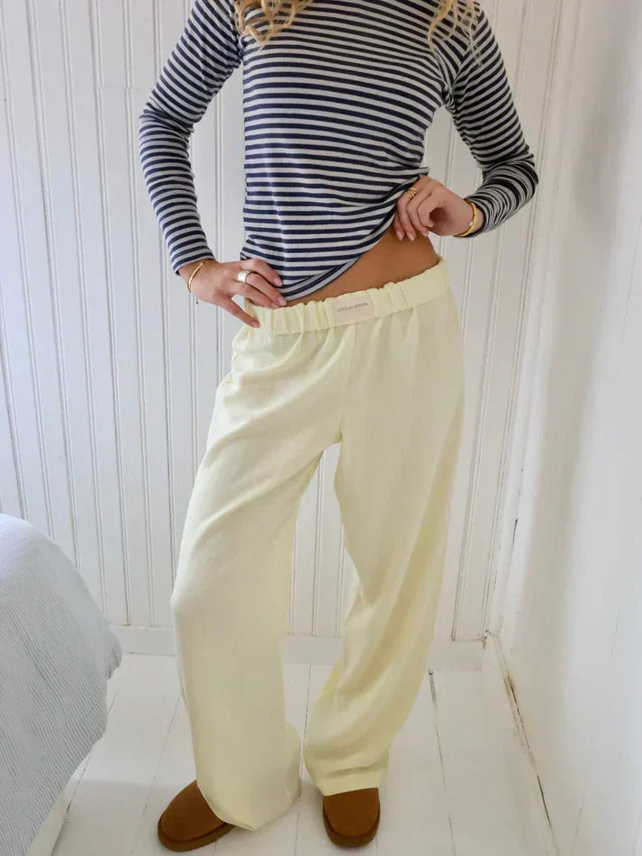 Modella in piedi con pantaloni a righe, perfetti per un look casual e alla moda.