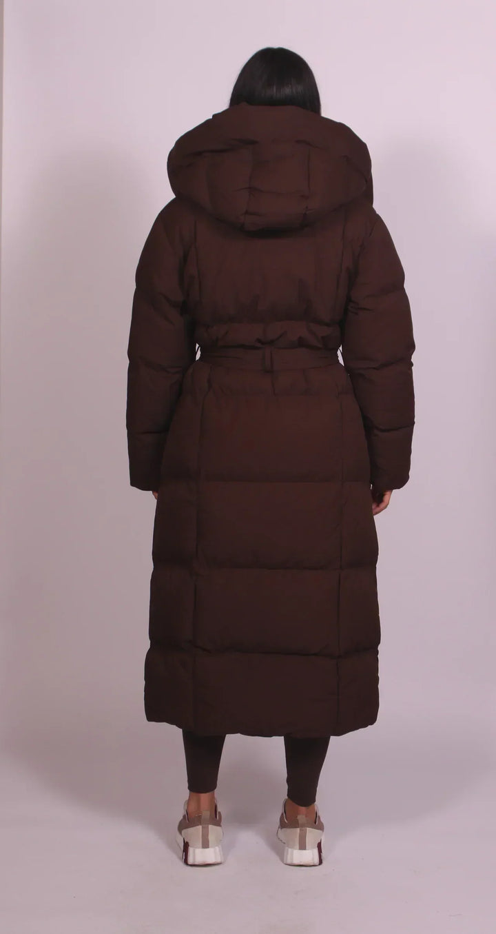 Piumino donna lungo elegante con cintura, cappuccio e collo alto, perfetto per un inverno caldo e alla moda.