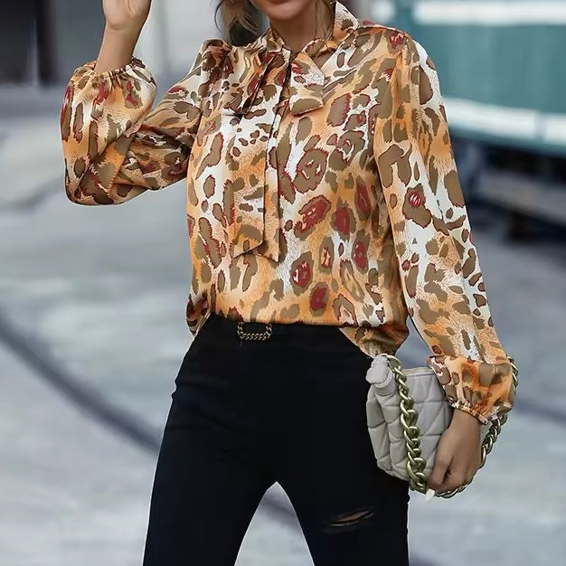 Blusa donna elegante con vivace stampa animalier e distintivo fiocco al collo. Perfetta per l'ufficio.
