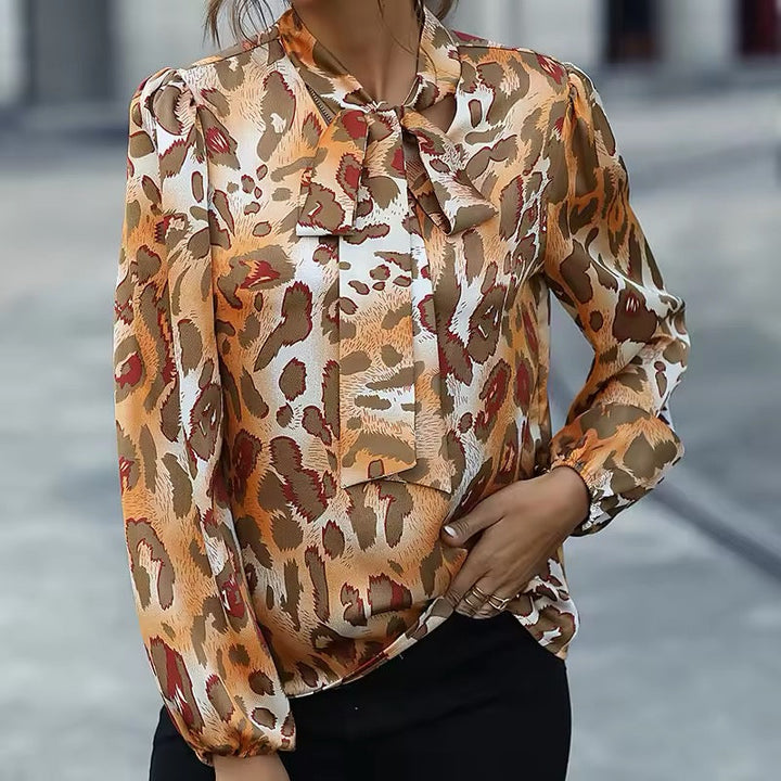 Blusa femminile a stampa animalier con fiocco decorativo al collo. Morbida e versatile per ogni occasione.